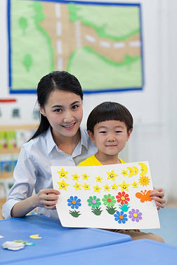 幼儿园女老师和儿童展示手工儿童画