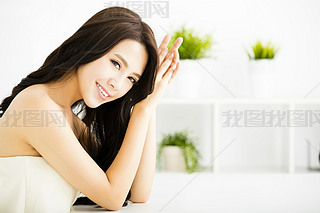 Smiling young beautiful woman sitting in living room