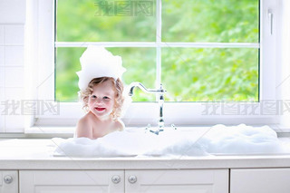 Baby girl taking bath with foam