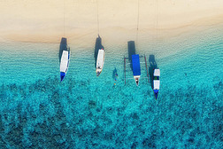 从顶视图可以看到水面上的船。从顶部的视图绿松石水的背景。来自空气的夏季海景。印度尼西亚吉利梅诺岛。旅行-图片