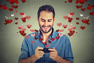 man sending love s message on mobile phone with hearts flying away