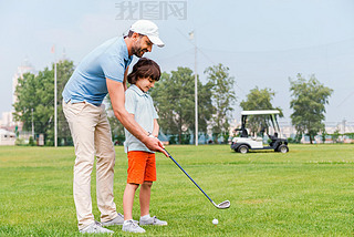 man teaching his son to play golf