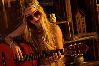 woman in boho style playing guitar
