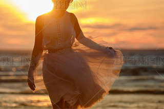 The silhouette of a slim girl in lush pink short skirt, standing