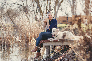 Beautiful girl with pets near the lake