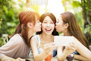 Group of friends taking selfie in garden restaurant