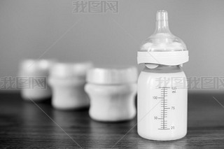 Baby bottle with milk and a measuring scale