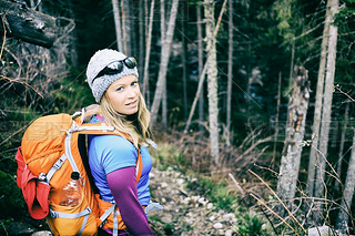 Woman hiking in winter cold dark winter forest
