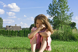 坐在草地上的小女孩在哭