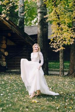 快乐的新娘在大自然中摆着飘动的连衣裙。艺术品