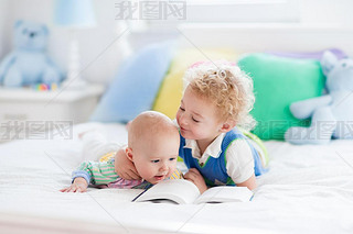 Little brothers reading a book in bed