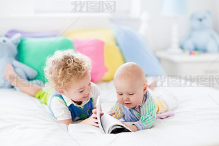 Little brothers reading a book in bed