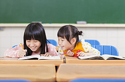 可爱的小女生看她同学的家庭作业
