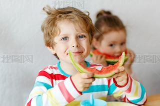 Little kid boy and girl eating healthy food watermelon