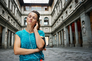 Portrait of relaxed young woman in sportswear listening mp3