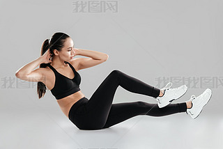Attractive young woman athlete working out and doing exercises