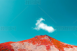 red mountain and cyan blue sky with one cloud