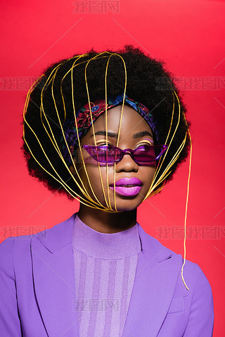african american young woman in purple stylish outfit and sunglasses with yellow strings on face iso