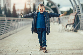 Little boy walking on bridge. 