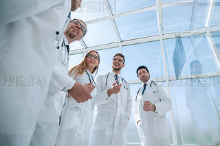 through the glass. group of doctors discussing current tasks