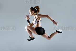 Fit and sporty young woman running on white background.