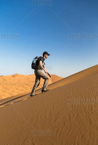 One man climbing a sand dune