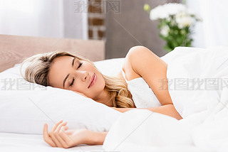 Young woman in pajamas sleeping on white bedding at home 