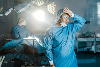 doctor in uniform and medical mask looking away in operating room