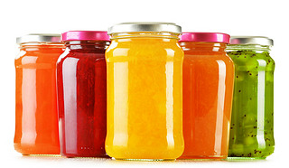 Jars of fruity jams isolated on white background