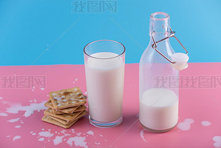 Glass bottle of fresh milk and cookies on pastel background. Colorful minimali. The concept of hea