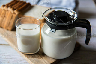 Close up of glass of milk and milk jug with use of selective focus