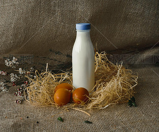 bottle of milk and eggs. rustic style on burlap background