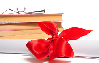 Diploma with stack of books and glasses