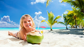 Little Girl Drinking Coconut Cocktail On Tropical Beach