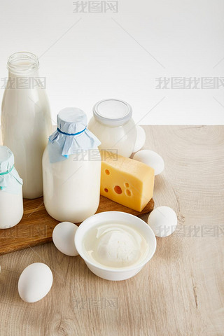 various fresh organic dairy products and eggs on wooden table isolated on white