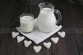 jug and glass with milk , heart cookies