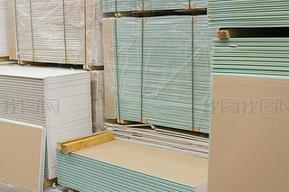 Gypsum plasterboard in the pack. The stack of gypsum board preparing for construction. Pallet with p