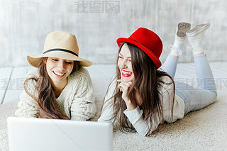 Best friends with laptop together sitting at cafes terrace