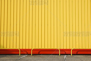 Detail of bright yellow metal building facade. For background