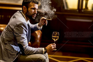 Man tasting wine and oking cigar