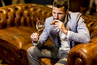 Man tasting wine and oking cigar