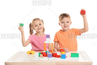 Cute little children playing with building blocks at table on white background