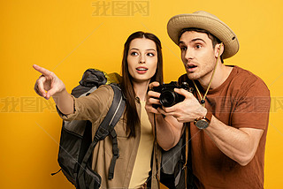 couple of shocked tourists with photo camera pointing on yellow