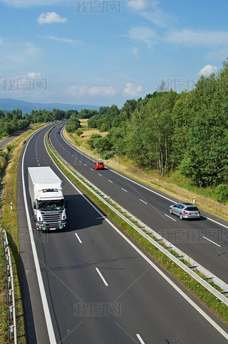 Highway passing through the countryside, truck and passenger cars