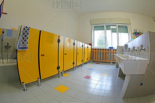 clean toilets of the school and ceramic sinks and yellow doors without the kids and a bright window