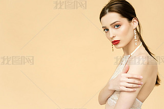 attractive young woman looking at camera isolated on beige with copy space