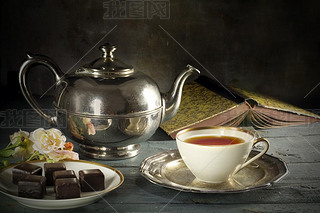 tea in a porcelain cup, old fashioned silver teapot, chocolate c