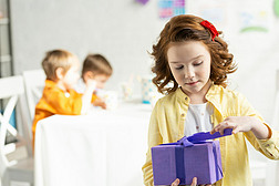 在生日庆祝活动中, 可爱的孩子在礼物的选择性焦点