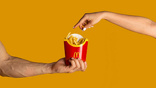 KHAV, UKRAINE - APRIL 4, 2020: Men and woman with package of french fries from McDonalds on orang