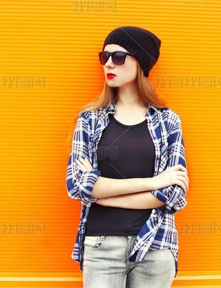 Fashion pretty woman wearing a black hat, sunglasses and shirt o